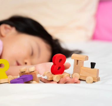 Slapend kind met educatief speelgoed – slaap bevordert leerontwikkeling en geheugen na spelen.